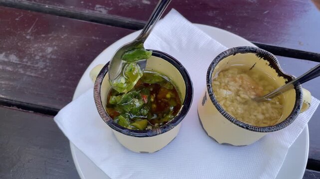 Homemade chillies and garlic in rustic small enamel serving cups. 