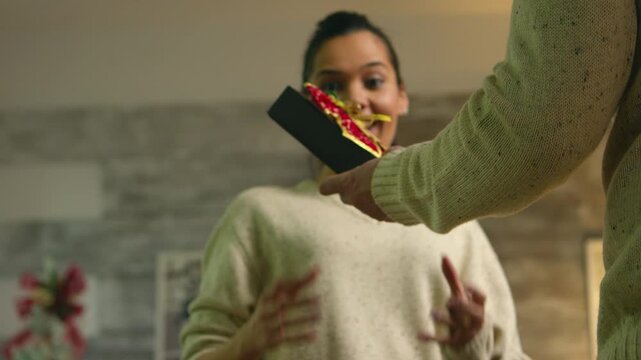 Man hiding wrapped Christmas gift behind his back