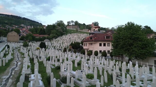 Aerial view of the historic Kovaci Memorial Cemetery with white stone tombstones on a hillside in Sarajevo, Federacija Bosne i Hercegovine, Bosnia and Herzegovina.
