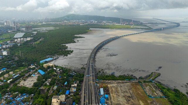Aerial view of the Atal Bihari Vajpayee Sewri-Nhava Sheva Atal Setu bridge stretching across the sea, surrounded by lush mangroves and urban infrastructure in Mumbai, Maharashtra, India.