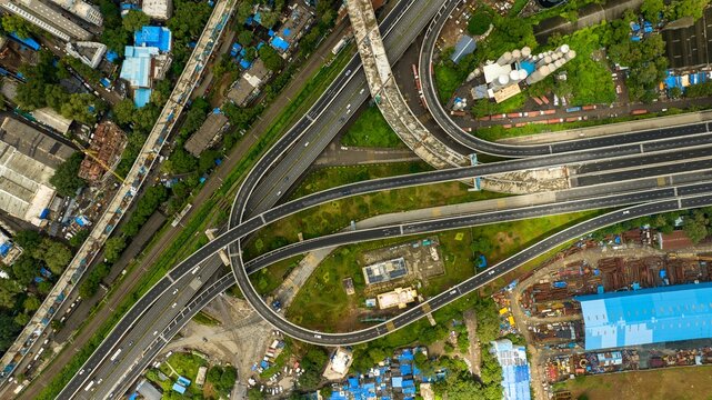 Aerial view of the Atal Bihari Vajpayee Sewri-Nhava Sheva Atal Setu, a complex highway interchange with multi-level flyovers and surrounding industrial structures in Mumbai, Maharashtra, India.