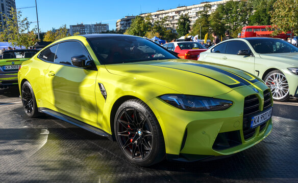 Vibrant yellow BMW M4 G82 coupe with black racing stripes, vertical grilles, and aggressive aero styling, showcasing modern BMW M performance heritage