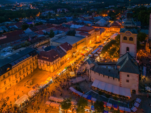 Aerial view of Radvansky jarmok traditional market with illuminated stalls and crowds of people in the historic square of Banska Bystrica, Banskobystricky kraj, Slovakia.