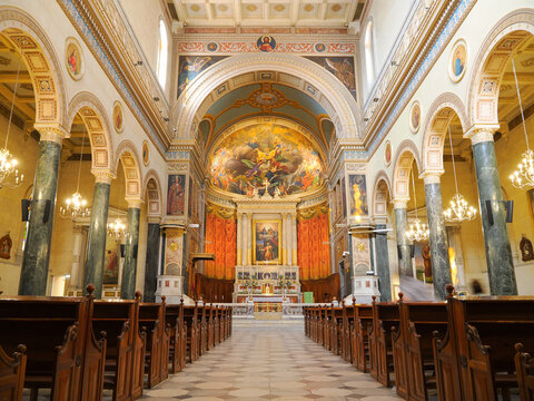 Grand cathedral nave featuring classical architecture, marble columns, wooden pews and elaborate apse