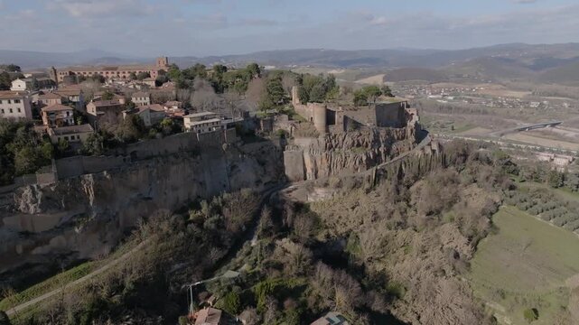 Aerial view of Orvieto perched on a volcanic tuff cliff with historic stone buildings and surrounding landscape in Orvieto, Umbria, Italy.