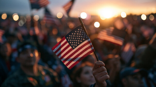 Person Holding American Flag in Crowd at Sunset