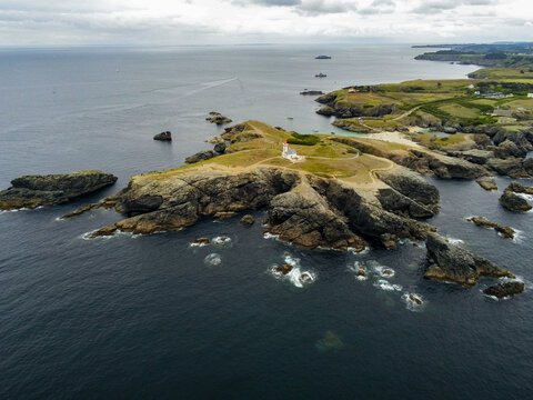 Aerial view of the Pointe des Poulains lighthouse situated on a rugged rocky peninsula surrounded by the Atlantic Ocean in Sauzon, Bretagne, France.