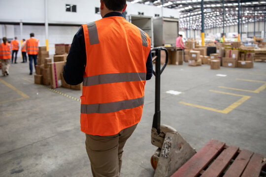 Warehouse Worker Wearing Safety Vest Moving Pallet