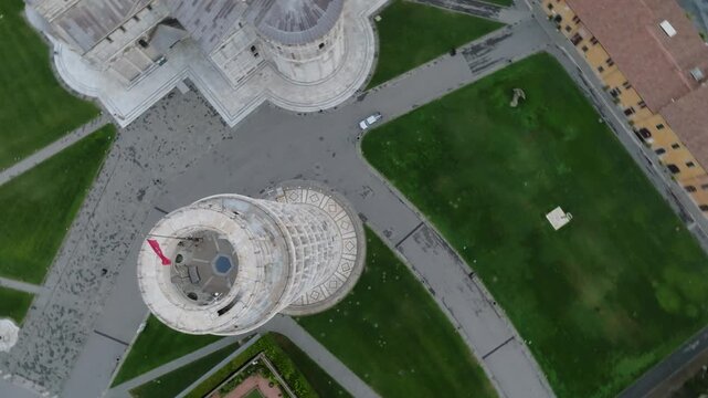 Aerial view of the Leaning Tower of Pisa and the surrounding cathedral complex with green lawns and stone pathways in Pisa, Toscana, Italy.