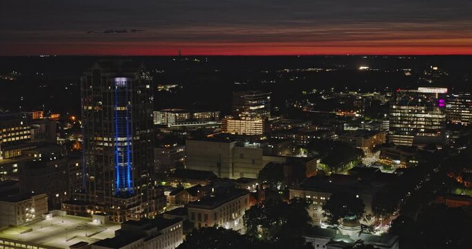 Raleigh North Carolina Aerial v35 tracking flyover capital district capturing illuminated downtown cityscape against dusk sky at night - Shot with 8k Camera - Sept 30th 2023