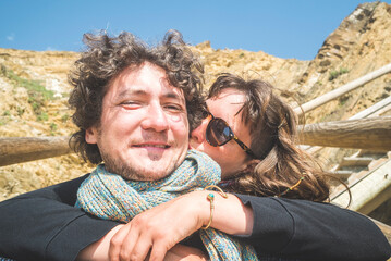 Fototapeta premium Happy couple selfie embracing outdoors near rocky terrain