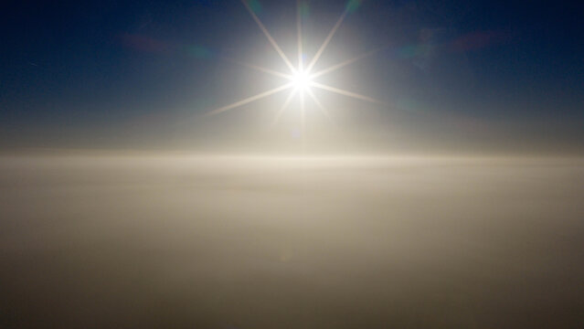 Aerial view of a thick layer of clouds illuminated by the bright sun above in Salisbury, England, United Kingdom.