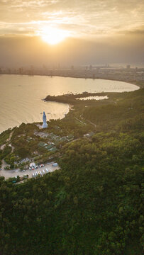 Aerial view of the Lady Buddha statue at Linh Ung Pagoda overlooking the coastline and city skyline of Da Nang, Vietnam.