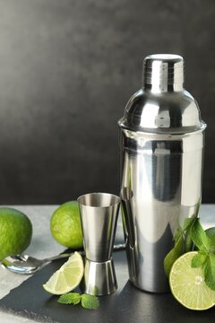 Ingredients for mojito, shaker, jigger and spoon on light grey table. Space for text