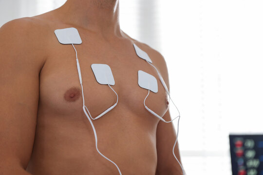 Patient with ECG electrodes attached to his chest in clinic, closeup. Space for text