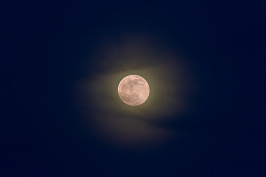 Full moon in the night sky with clouds