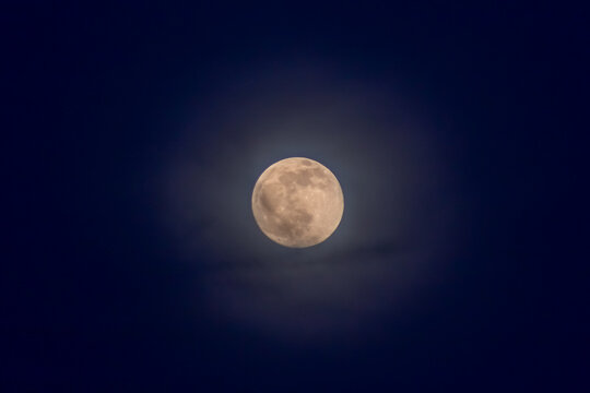 Full moon in the night sky with clouds