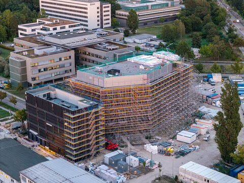 Aerial view of Helmholtz-Zentrum Berlin Science Campus with research buildings, extensive scaffolding on construction sites, and surrounding greenery in Berlin, Berlin, Germany.