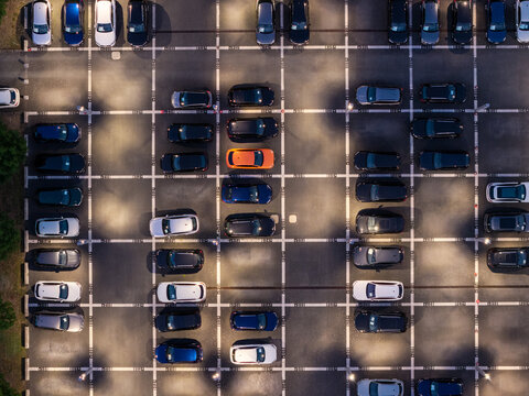 Aerial view of Audi Zentrum Berlin Adlershof parking lot filled with various cars including a bright orange vehicle parked in marked spaces Berlin, Berlin, Germany.