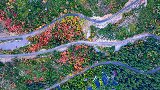 Cars driving along the switchbacks on the Alpine Loop Scenic Byway in autumn - top down static aerial view