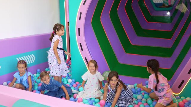 Kids throwing balls in colorful indoor play area