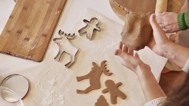 High Angle View of Hands Preparing Traditional Christmas Gingerbread Cookies with Metal Cutters