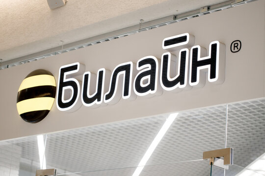 KIROV, RUSSIA - September 26, 2026: Beeline telecommunications store sign in Cyrillic with black and yellow striped circular logo above a bright retail entrance interior
