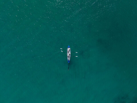 Aerial view of a rowing boat with rowers on the turquoise ocean, Dee Why, New South Wales, Australia.