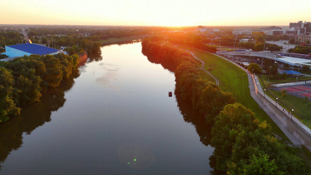 Aerial view of the White River at sunset with lush green banks and urban infrastructure in Indianapolis, Indiana, United States.