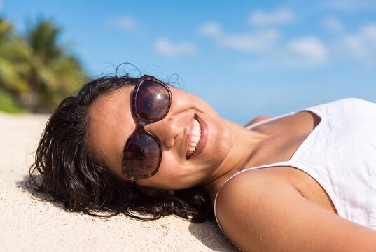 Woman Relaxing on Tropical Beach Sand Wearing Sunglasses During Summer Vacation