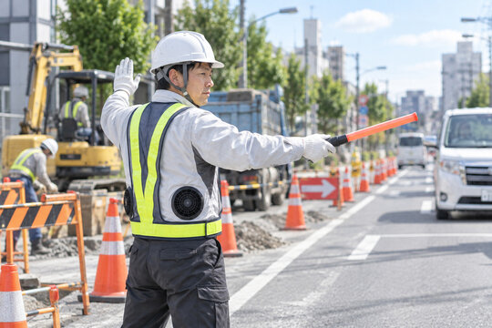 空調服を着た作業員の道路工事での交通誘導