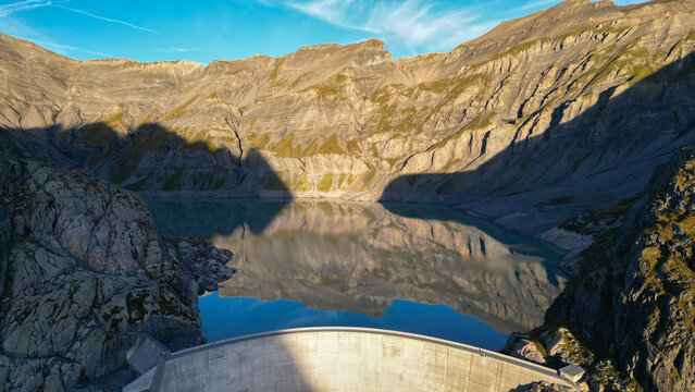 Aerial view of the Vieux Emosson dam and lake, surrounded by rugged rocky mountain peaks and steep slopes in Finhaut, Valais, Switzerland.