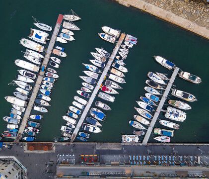 Aerial view of the Old port of Jaffa with numerous boats docked at piers in the calm turquoise water of the Mediterranean Sea in Tel Aviv-Yafo, Tel Aviv District, Israel.