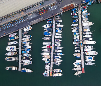 Aerial view of the old port of Jaffa with numerous boats docked at piers in the turquoise water of the Mediterranean Sea in Tel Aviv-Yafo, Tel Aviv District, Israel.