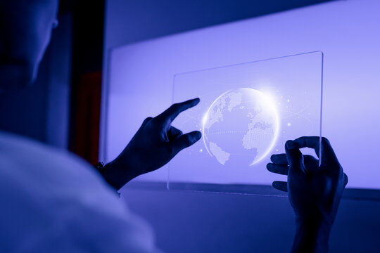 Hands interacting with a glowing digital globe on a transparent screen