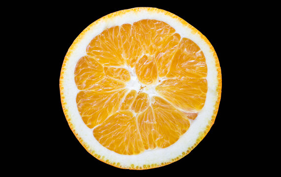 Cross-sectional view of a fresh orange slice showing its segments, pith and rind, isolated on a black background.