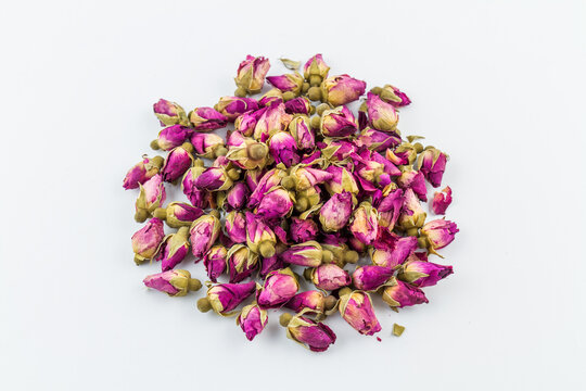 A pile of dried rose buds, a common herbal tea ingredient, displayed on a plain white background.