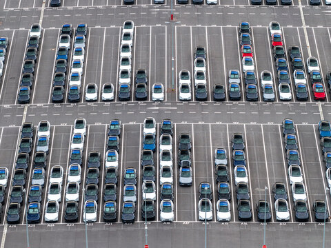 Aerial view of Tesla Gigafactory Berlin-Brandenburg showing rows of new electric cars parked in a large asphalt lot. Grunheide Mark, Brandenburg, Germany.