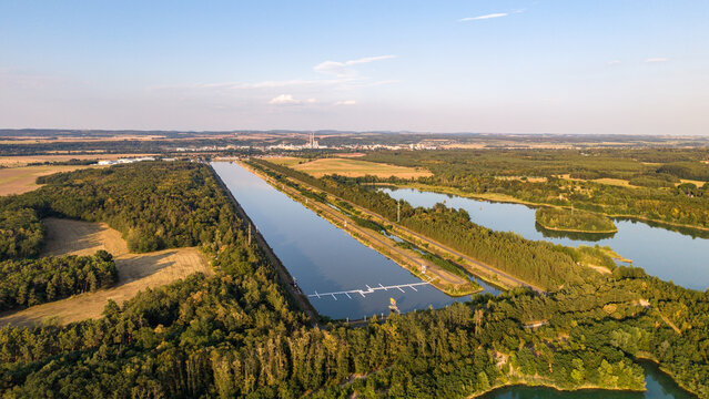 Aerial view of Labe Arena Racice, a rowing canal surrounded by lush forests and agricultural fields in Racice, Ustecky kraj, Czechia.