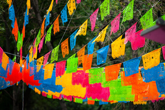 Colorful paper decorations (Papel Picado) hanging in the streets of Mexico City during the Day of the Dead (Dia de Muertos) festivities.