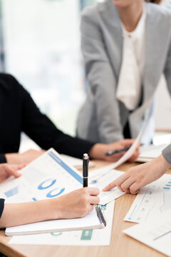 Close Up Businesspeople Writing Notes and Pointing Financial Document in Vertical Framing
