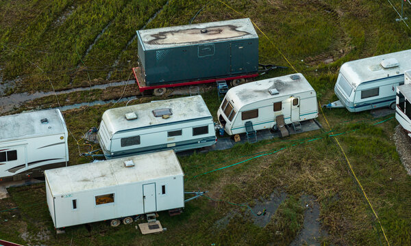Aerial view of several caravans and trailers parked on a muddy grassy field in Vilnius, Vilnius County, Lithuania.