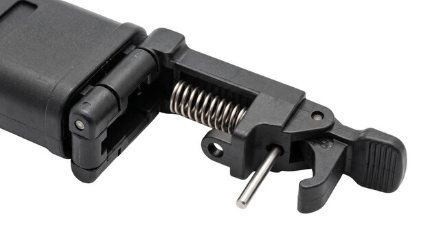 Black plastic spring clamp mechanism detail, durable polymer latch assembly with steel coil spring, macro shot of hinge component