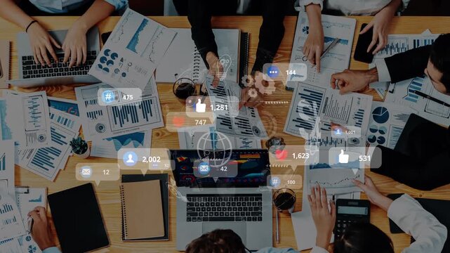 A vibrant business meeting scene showcasing professionals engaging over data analysis. Laptops and documents with various charts and graphs clutter a collaborative workspace. Raster