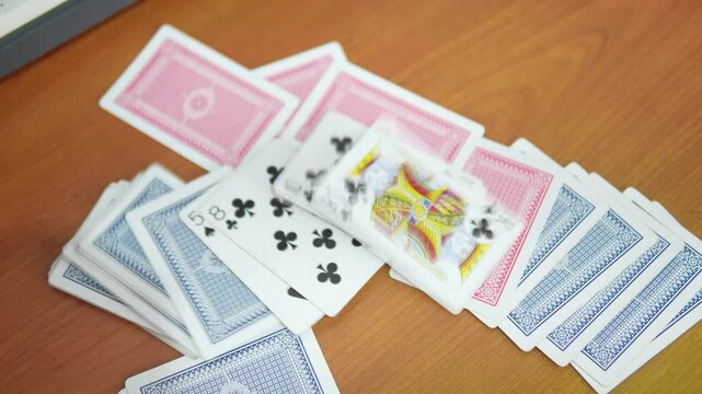 Playing cards spread out on a wooden table