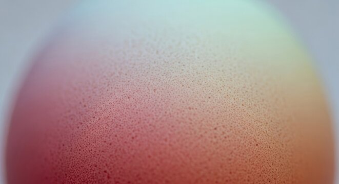 Extreme macro close-up of a brown eggshell showing its natural porous surface texture with a soft gradient of reddish-brown to light beige colors under soft diffused lighting.