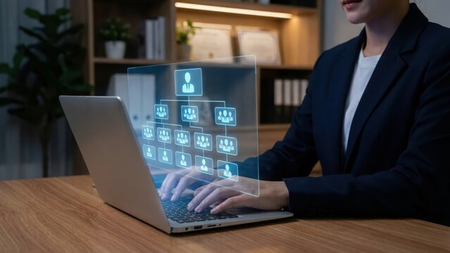 Corporate manager using laptop to view digital organizational chart hologram for human resources management and team structure planning