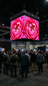People watching a large digital display screen at an exhibition
