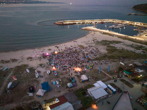 Aerial view of the Quarantine Film Festival on the beach with a large crowd, small boats, and a marina in the background in Asparuchovo, Varna, Bulgaria.