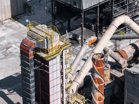Aerial view of the Sacci S.P.A. cement factory featuring industrial towers, rusted metal pipes, and concrete structures in Castelraimondo, Marche, Italy.